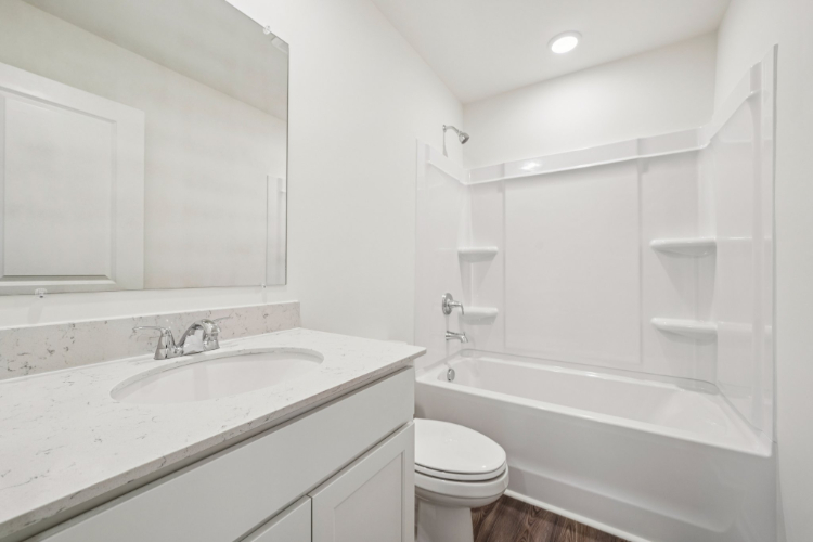 A bathroom with a tub sink and toilet.