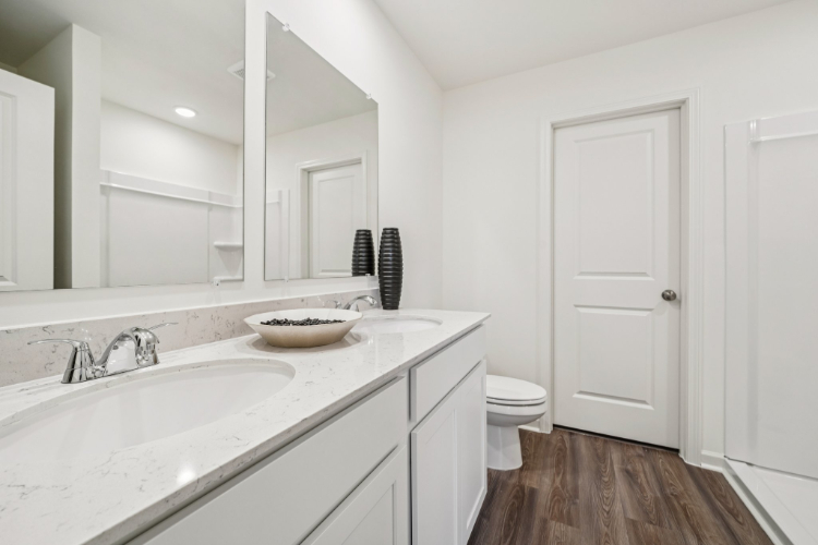 A bathroom with a sink toilet and mirror.