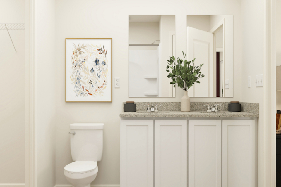 A bathroom with a plant on the counter.