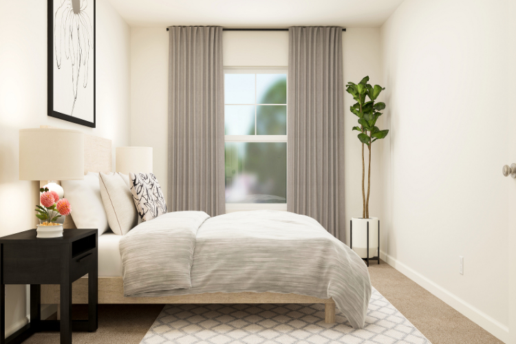 A bedroom with a bed and a plant.