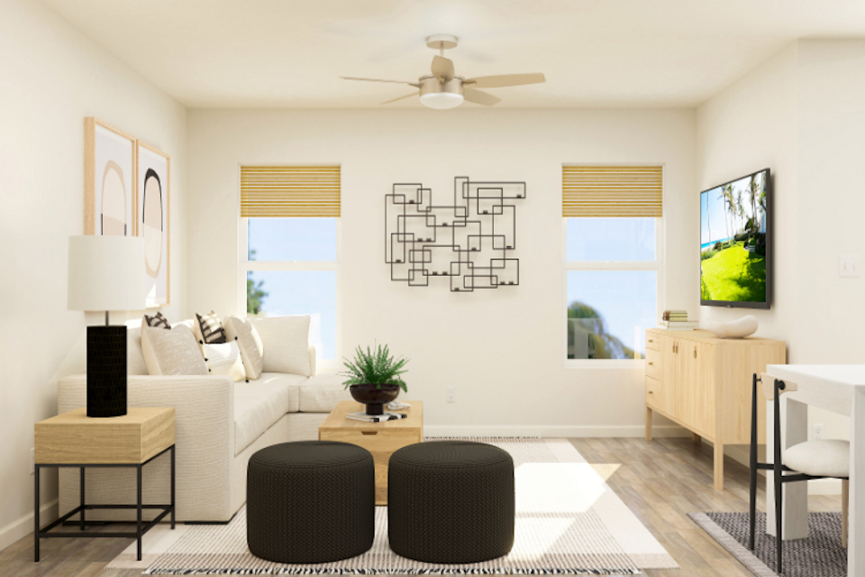 A living room with a white couch and a black chair.