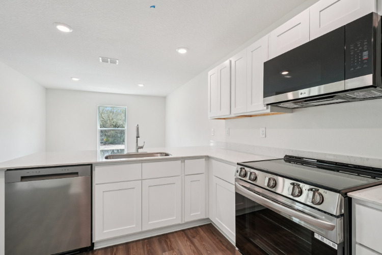 A kitchen with white cabinets.