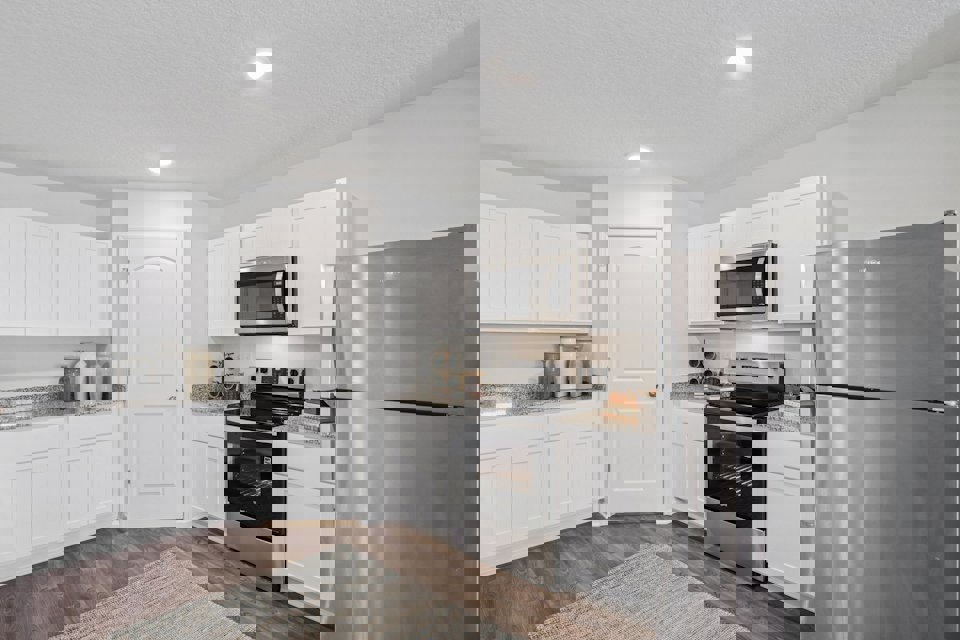 A kitchen with white cabinets.