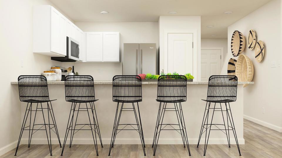 A kitchen with a table and chairs.