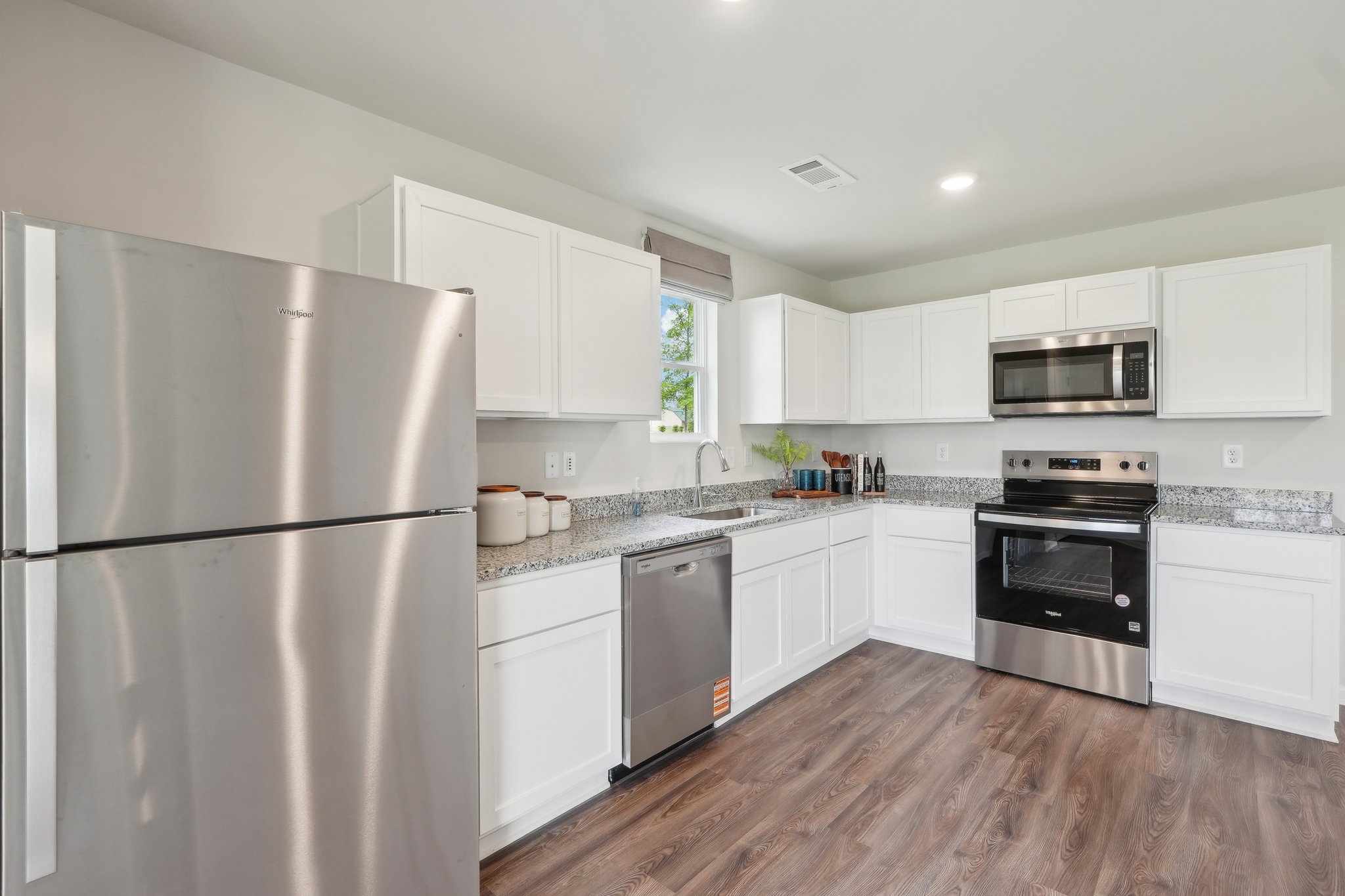 A kitchen with white cabinets.