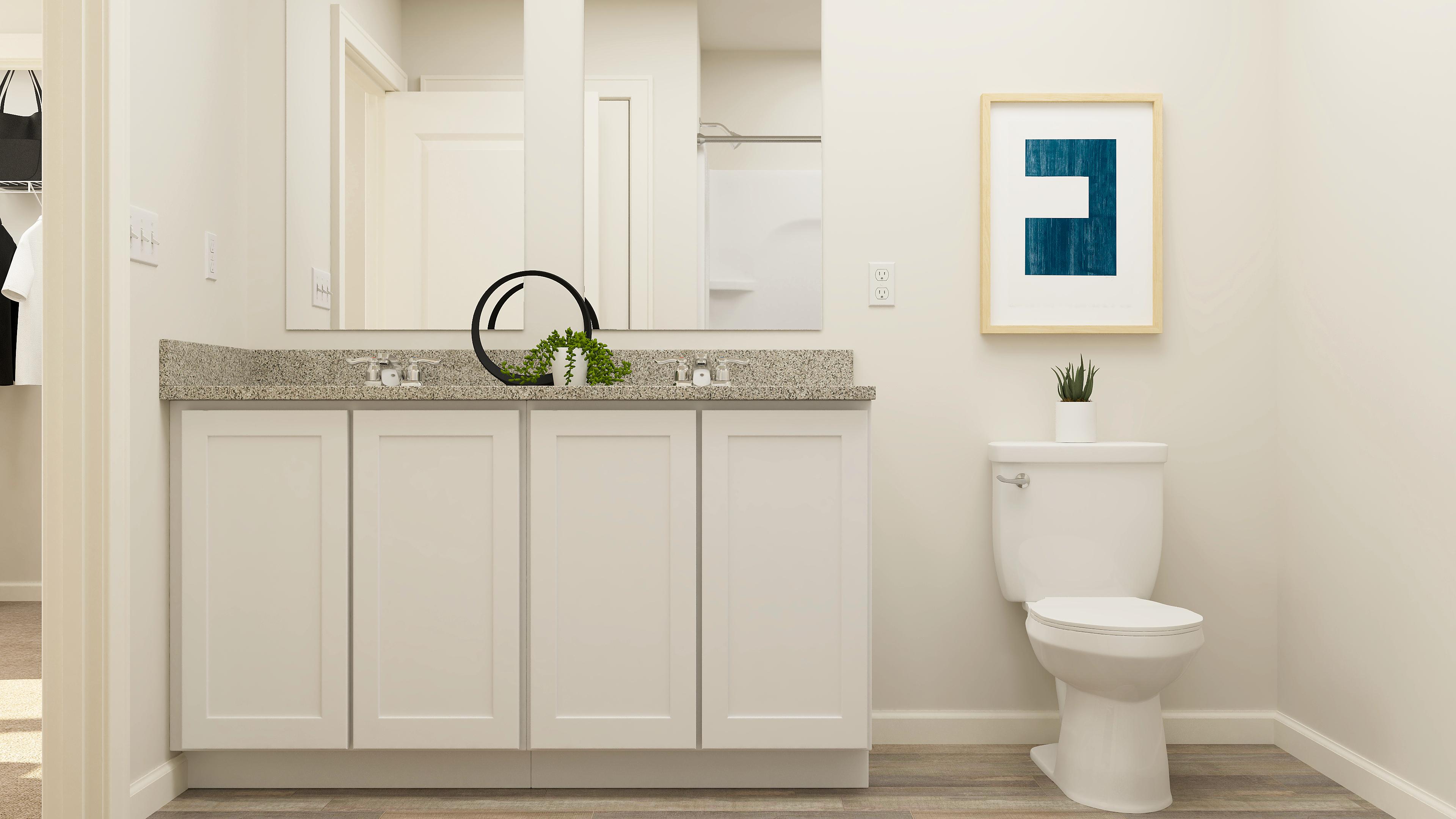 A bathroom with white cabinets.
