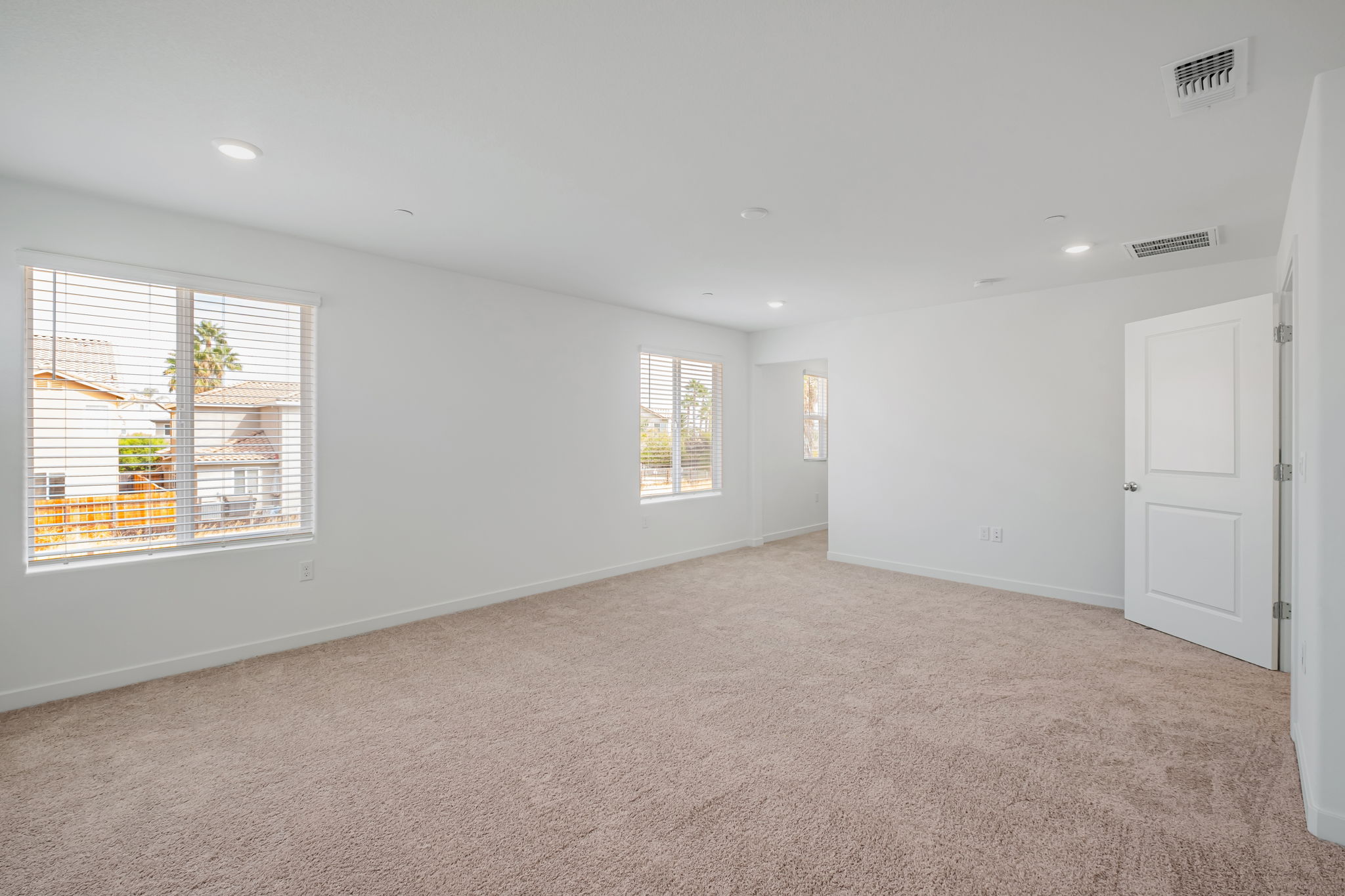 A room with a carpet and windows.